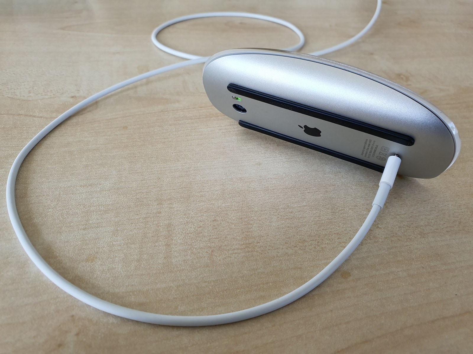 An Apple Magic Mouse turned upside down and unusable while charging through its underside port